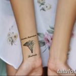 Фото тату с изображением медицинского креста, надписями 'Insulin Dependent' и 'Diabetic' на запястье. Рисунок выполнен в черном цвете.