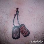 Фото тату, имитирующего два армейских жетона на цепочке, с надписями 'Severe Hemophilia Type-A' и 'Blood Type'. Расположение - область груди.