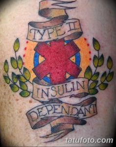 Фото тату креста жизни красного цвета с надписями 'Type II', 'Insulin Dependent' на лентах, окруженного зелеными листьями. Расположение - предплечье.