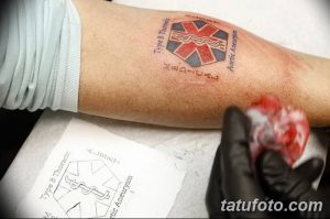 Фото татуировки на предплечье с изображением гексагонального символа и надписью о типе аневризмы, выполненной в цветном стиле.