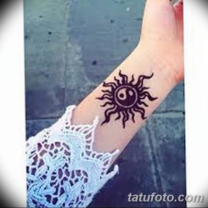 Фото тату Mehndi: забавный рисунок солнца с улыбающимся лицом, нанесенный на руку.