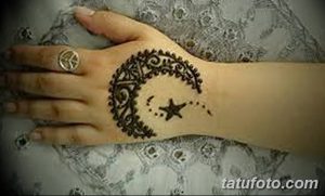 Фото тату Mehndi: изящный рисунок полумесяца, украшенный сложным орнаментом и звездой, нанесенный на руку.