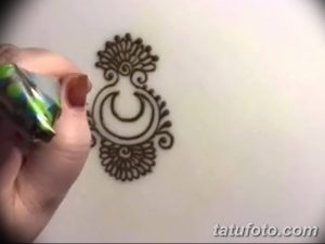 Фото тату Mehndi: небольшой рисунок полумесяца с декоративными элементами, нанесенный на руку.
