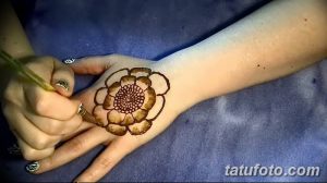 Фото процесса нанесения тату хной на руку, изображающее цветок с детально прорисованными лепестками. Идеально для тех, кто интересуется искусством мехенди.