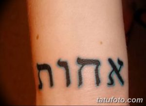Фото тату: небольшая надпись на иврите, выполненная черными чернилами, расположена на руке. Минималистичный и стильный дизайн.