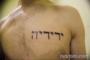Фото тату: черная ивритская надпись, расположенная на груди мужчины. Четкий шрифт, минималистичный дизайн. Идеи для тату.