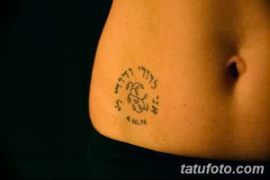 Фото тату: Небольшая татуировка на боку с изображением животных и ивритским текстом, обрамленными кругом. Милый и нежный дизайн.