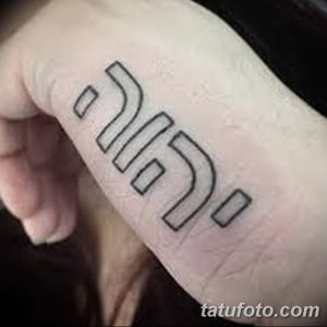 Фото минималистичной ивритской татуировки на руке. Черные чернила, четкие линии, простой дизайн. Идея для тех, кто ищет небольшую и стильную татуировку.