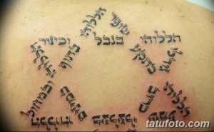 Фото тату: сложный геометрический узор с ивритскими надписями, образующий круг на спине. Мистический и мощный рисунок татуировки.