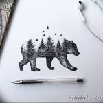 Черно-белое фото тату медведя, силуэт которого заполнен изображением соснового леса. Изображение выполнено в детализированном графическом стиле.