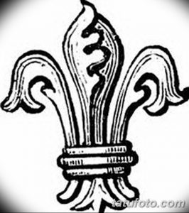 Черно-белое фото тату с изображением лилии, выполненной в стиле старой школы. Рисунок имеет грубые линии и нарочитую простоту, что придает ему винтажный вид.