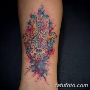Фото акварельной татуировки Хамсы на предплечье. Яркие цвета и размытые края создают эффект акварельной живописи.