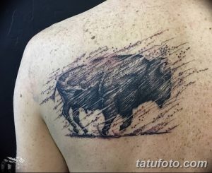 Фото тату бизона в стиле лайнарт на плече, выполненной тонкими черными линиями и точками, создающими эффект движения и динамики.