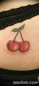 Фото тату двух вишен на животе. Нежный и привлекательный рисунок, подчеркивающий женственность и красоту тела.