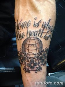 Фото татуировки на руке с изображением глобуса и фразой 'Home is where the heart is'. Идеальный рисунок татуировки для путешественников.
