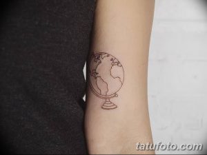Фото тату глобуса в минималистичном стиле на руке. Тонкие линии, простой рисунок, акцент на контурах.