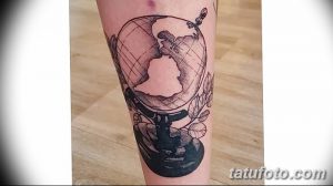Фото графичной татуировки на ноге с изображением глобуса, бабочки и листьев, выполненной в черных линиях.