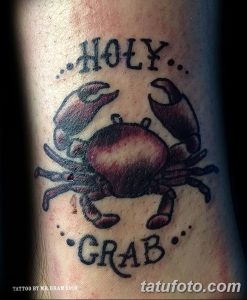 Фото татуировки краба в стиле олдскул с надписью "Holy Grab". Черно-белый рисунок с яркими контурами и традиционными элементами.