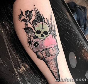 Фото тату: татуировка на руке с изображением мороженого в форме черепа, украшенного цветами и глазом. Оригинальный и жуткий дизайн.