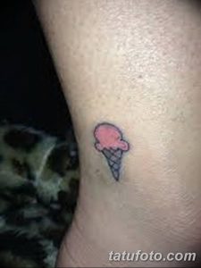 Фото маленькой татуировки в виде розового мороженого на запястье. Простой и милый рисунок татуировки.