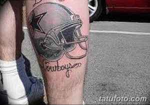 Фото татуировки на ноге с изображением шлема футбольной команды Dallas Cowboys. Тату выполнено в черно-серых тонах.