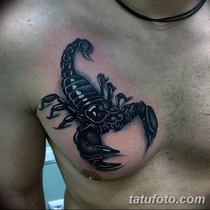 Фото тату черного скорпиона на груди. Крупный, детализированный рисунок татуировки с акцентом на мощные клешни и изогнутый хвост.