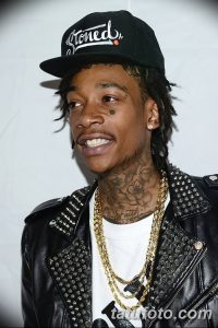 Фото тату на лице и шее рэпера Lil Wayne. Изображены черные татуировки в виде цветов и надпись 'Faith' на шее.
