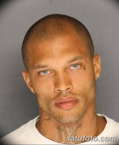 Фото тату: крупный план татуировки на шее мужчины с бритой головой. Рисунок выполнен в черных тонах, с использованием геометрических узоров и символов.