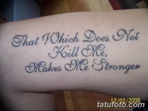 Фото тату: черная надпись на предплечье гласит 'That Which Does Not Kill Me, Makes Me Stronger'. Изящный шрифт и четкие линии.