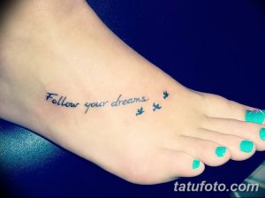 Фотография минималистичной татуировки на стопе с надписью 'Follow your dreams' и изображением трех маленьких птиц, выполненной в черном цвете.