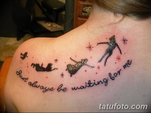 Фото тату на лопатке с изображением Питера Пэна и надписью 'Just always be waiting for me'. Мультяшный стиль, яркие цвета, вдохновляющий сюжет.