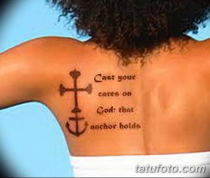 Фото татуировки на спине с изображением креста и якоря, а также надписью 'Cast your cares on God that anchor holds'.