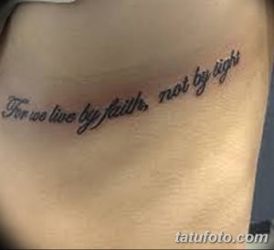 Фото тату надписи 'For we live by faith, not by sight' на боку. Черные чернила, каллиграфический шрифт. Идея для религиозной татуировки.