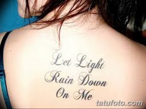 Фото тату надписи 'Let Light Rain Down On Me' на спине девушки. Черные чернила, красивый шрифт. Идея для тату с духовным смыслом.