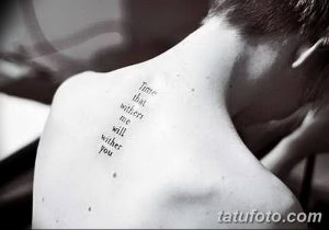 Фото тату надписи 'Time that withers me will wither you' на спине, между лопатками. Черный цвет, тонкие линии, каллиграфия, лиричный смысл.