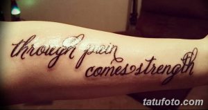 Фото тату с надписью 'Through pain comes strength', выполненной каллиграфическим шрифтом на предплечье. Черно-белая татуировка, символизирующая преодоление трудностей и обретение силы.