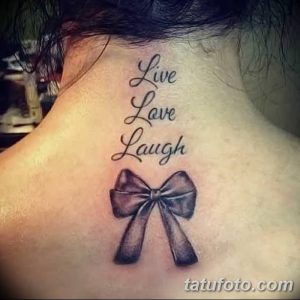Фото тату: надпись "Live, Love, Laugh" и изображение бантика на затылке девушки. Милая и вдохновляющая татуировка.