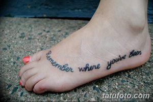 Черно-белое фото татуировки на стопе с фразой 'Remember where you’ve been'.
