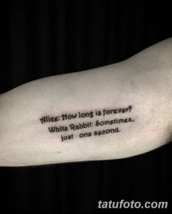 Фото тату надписи на предплечье: цитата из 'Алисы в Стране чудес' - 'Alice: How long is forever? White Rabbit: Sometimes, just one second'. Черный шрифт, минимализм.