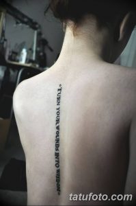 Фото тату надписи на спине: 'Turn Your Wounds Into Wisdom'. Черный шрифт, минимализм, вдохновляющая цитата, вертикальное расположение.
