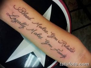 Фото тату надписи на предплечье: 'Blood Makes You Related, Loyalty Makes You Family'. Черный контур, каллиграфический шрифт, семейные ценности.