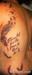 Фото татуировки с изображением пера, вылетающих птиц и цитаты 'There, but for the grace of God, go I' на спине мужчины.
