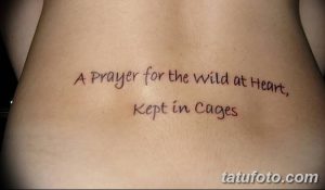 Фото татуировки с надписью 'A Prayer for the Wild at Heart, Kept in Cages' на пояснице женщины.