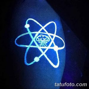 Фото тату: изображение атома, выполненное в технике UV татуировки на плече. Яркое неоновое свечение под ультрафиолетовым светом.