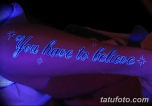 Фотография татуировки в виде надписи "You have to believe" на руке, выполненной светящимися в ультрафиолете красками. Рисунок украшен небольшими светящимися звездами.