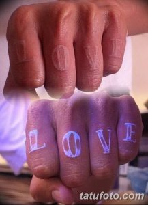 Фото тату на пальцах: слово "LOVE", нанесенное на каждый палец, светящееся под ультрафиолетом. Необычный и романтичный рисунок татуировки.
