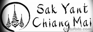 Фото татуировки Sak Yant в традиционном тайском стиле. Изображены геометрические символы и текст на тайском языке в черном цвете.