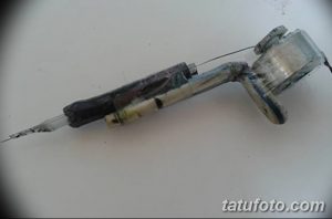 Фотография самодельной тату-машинки, собранной из ручки и небольшого мотора, обмотанной изолентой. Пример самодельного инструмента для татуировки.