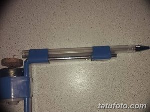 Фото самодельной тату-машинки, собранной из ручки и синего корпуса. Крупный план.