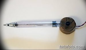 Фотография самодельной тату-машинки, сделанной из ручки и небольшого мотора. Устройство выглядит непрофессионально и потенциально опасно для использования.